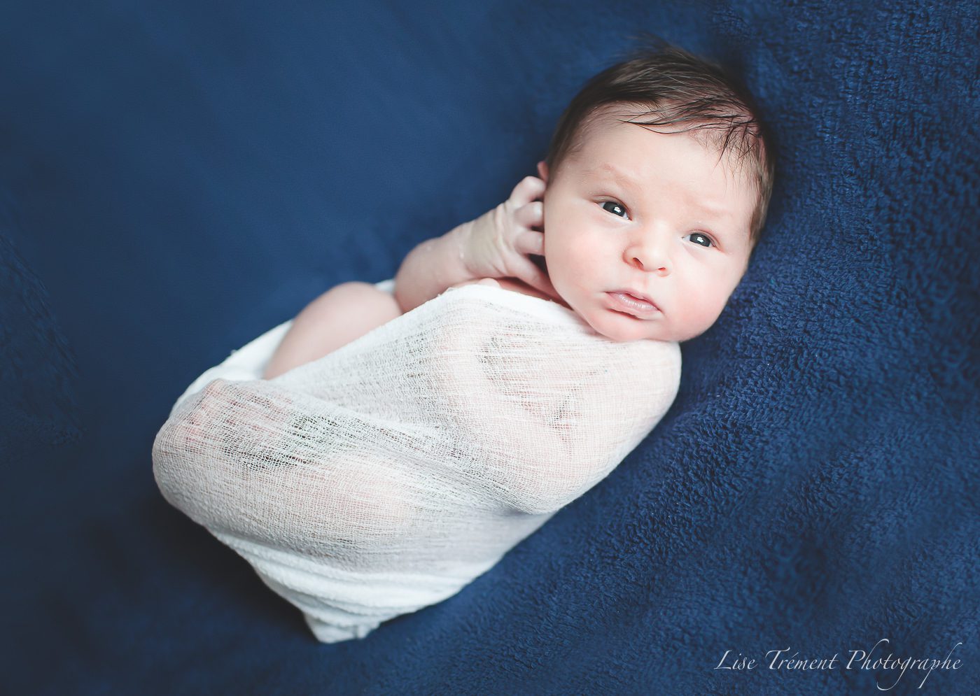 bébé allongé sur le dos, enroulé dans un wrap